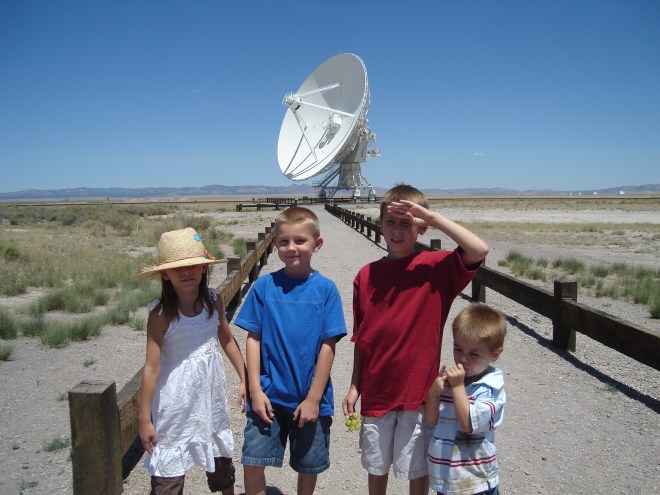 the kids in front of an parabolic dish
